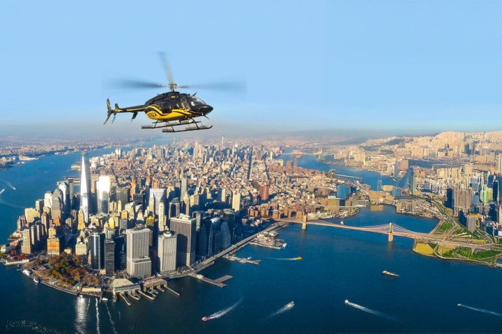 Helicopter flying over a large city skyline and rivers.