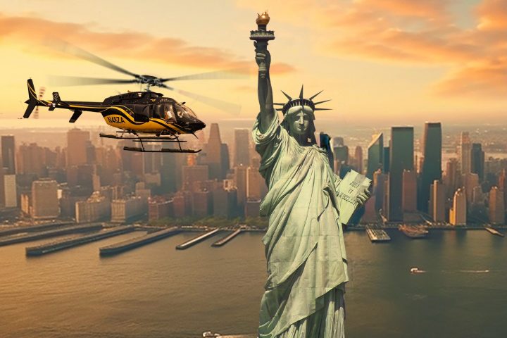 Helicopter flying near Statue of Liberty with city skyline in background during sunset.