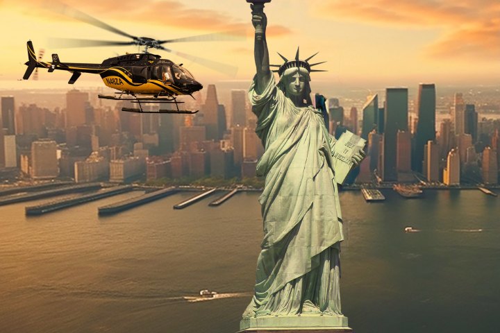 Helicopter flying near Statue of Liberty with city skyline in background during sunset.