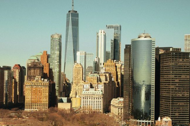 Aerial view of New York City skyline with tall skyscrapers and waterfront.